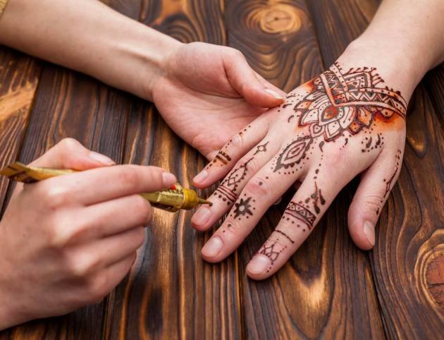 artist-making-mehndi-womans-hand